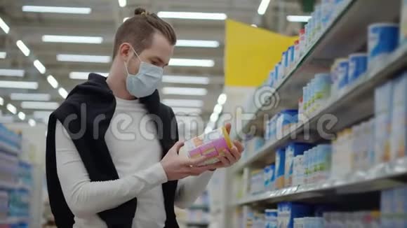 带防护面罩的顾客在超市选择婴儿食品视频的预览图