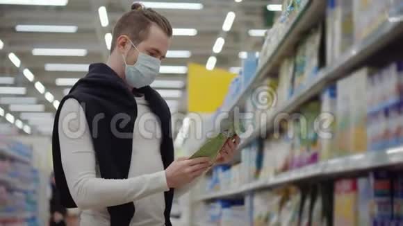 冠状病毒流行期间超市里戴面具的男人视频的预览图