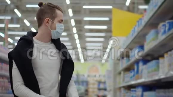冠状病毒流行期间超市里戴医疗面具的男人视频的预览图