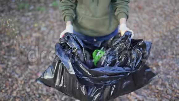 一位女志愿者在外面展示了一包收集的垃圾塑料瓶子生态污染视频的预览图