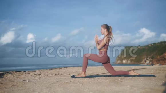 穿运动服的美女在海滩上练习瑜伽姿势视频的预览图