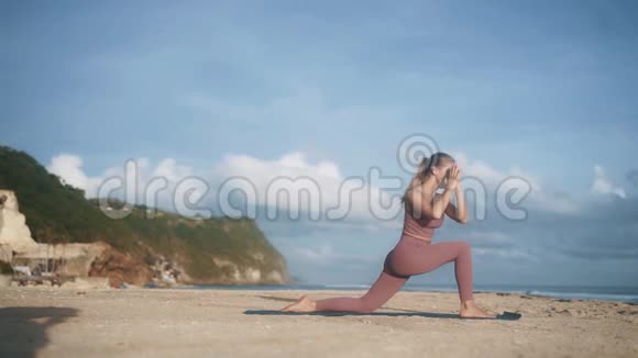 穿紫罗兰运动服的女人做瑜伽姿势伸展手臂视频的预览图