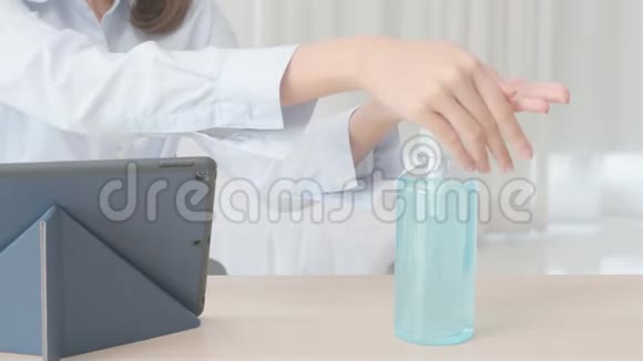 在工作前用酒精凝胶清洁她的双手并在工作时使用日光灯视频的预览图