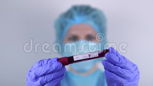 医生一个女人手里拿着一个带有艾滋病阳性检测的试管看着它视频的预览图