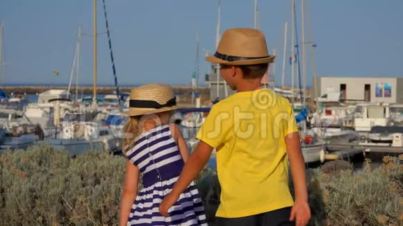 一个戴着帽子的男孩正在游艇码头上寻找视频的预览图