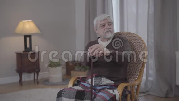 一幅不幸的白种人老人拿着拐杖望着一边叹息的肖像沮丧的高级退休人员视频的预览图