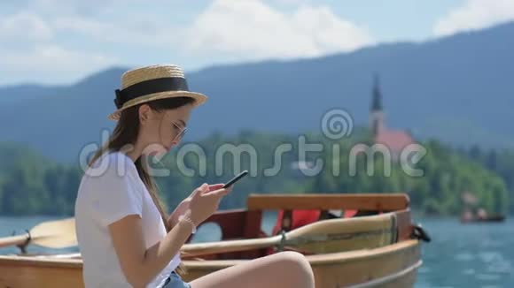 女人正在用智能手机拍摄湖上的岛屿景观视频的预览图