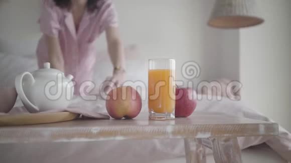 白种人模糊的女人从桌子上拿着新鲜的苹果在家里在床上爬行开心的微笑女士视频的预览图
