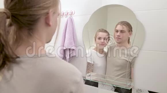 这对年轻夫妇站在白色的浴室里对着镜子看倒影视频的预览图