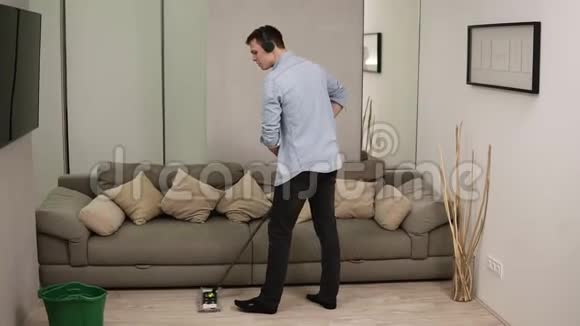 人家务和家务的概念快乐的人戴着耳机拖把清洁地板在家跳舞灰灰视频的预览图