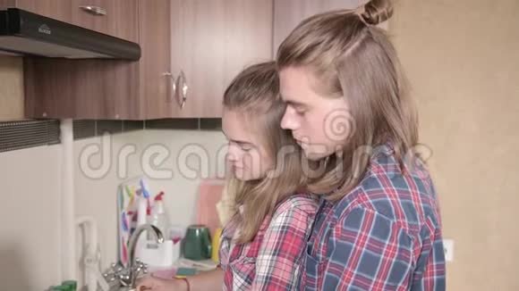 夫妇在厨房一起做饭男人拥抱女人每天的生活特写视频的预览图