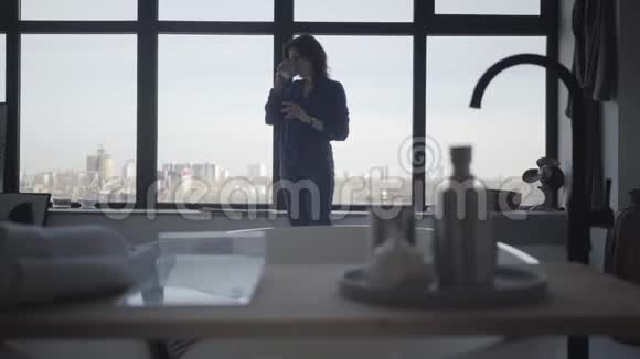 美丽的白种人女人喝咖啡在室内大窗户前伸展的肖像快乐成功视频的预览图