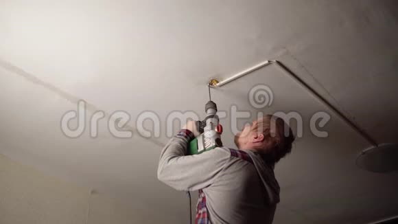电工钻一个洞把吊灯安装在天花板上视频的预览图