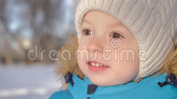 一个可爱的小男孩在冬天穿过公园户外娱乐视频的预览图