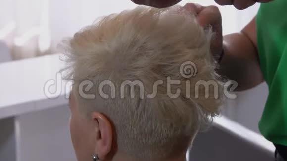 靠近理发师的手给客户做一个简短的发型视频的预览图