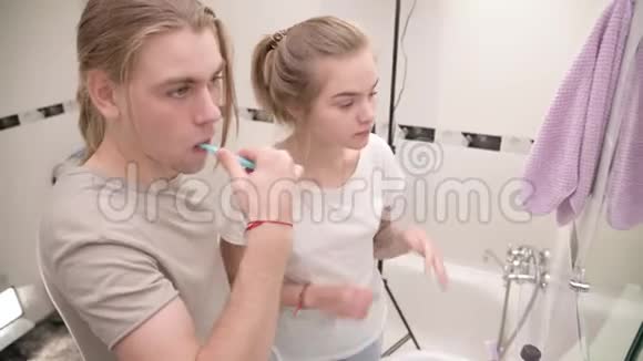 年轻夫妇在浴缸里男人刷牙女孩揉脸微笑特写视频的预览图