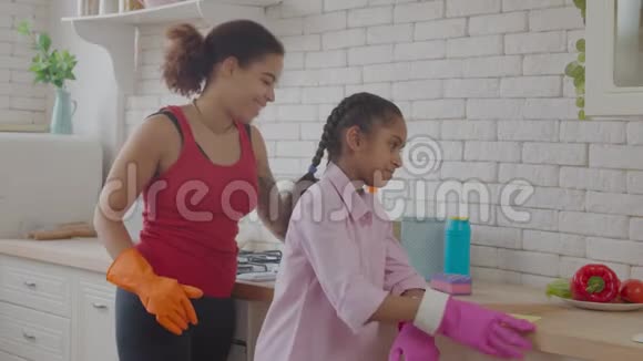 积极的妈妈和小孩清洁台面视频的预览图
