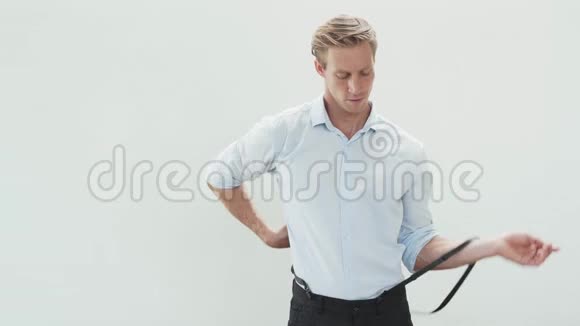 穿浅色衬衫的帅哥穿上吊带在白色背景上跳舞视频的预览图