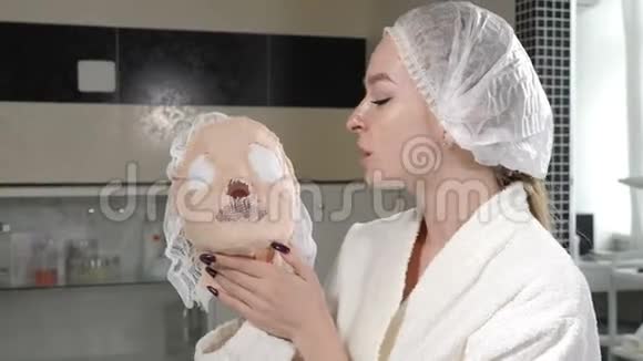 美丽的女人的肖像手里拿着坚硬的海藻酸钠面具在美容诊所里笑得开心概念视频的预览图