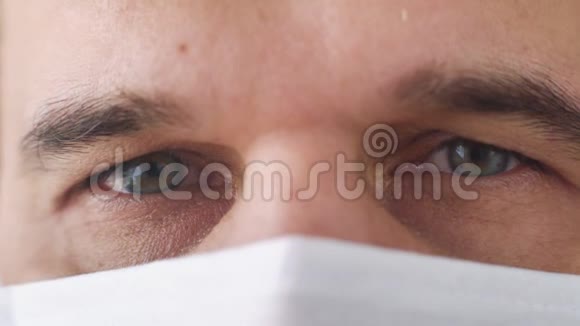 戴着医疗面罩的疲惫医生眼睛的宏观镜头视频的预览图