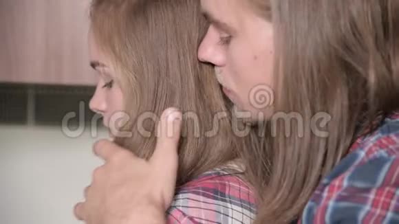 一个长发青年从背后抱住女朋友轻轻着她的肩膀特写视频的预览图