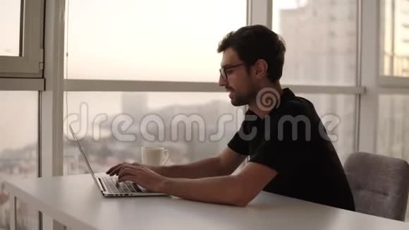快乐的男人在远程工作场所慢动作使用笔记本电脑自由职业者在家工作电脑好的视频的预览图