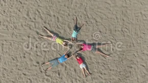 孩子们穿着鲜艳的衣服躺在沙子上形状像星星视频的预览图