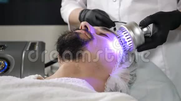 年轻的帅哥在美容院做美容手术硬件美容抗衰老抗皱视频的预览图