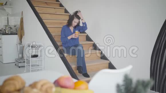 一位优雅的白种人深色头发的女士早上在家喝橙汁自信的肖像视频的预览图