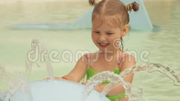 小可爱的女孩敲着喷泉里流淌的水流视频的预览图