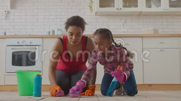 妈妈和女孩用清洁用品擦地板视频的预览图