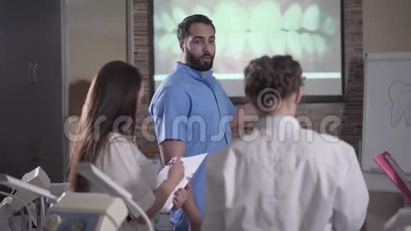 微笑中东讲师在屏幕前说话牙齿可视化自信的年轻人讲课视频的预览图