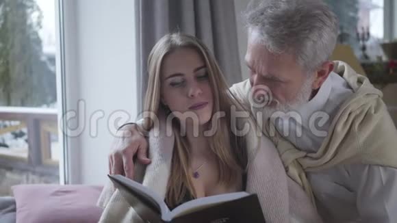资深白种人男人爱上了年轻漂亮的白种人女人看书幸福的爱情伴侣视频的预览图