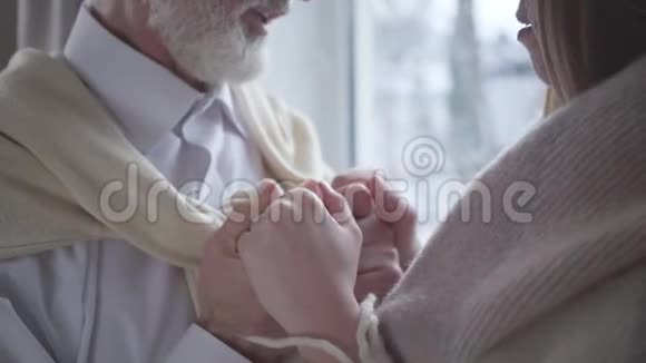 年长男人的特写亲吻女性白种人的手并微笑有年龄差异的恩爱夫妻的团结浪漫视频的预览图