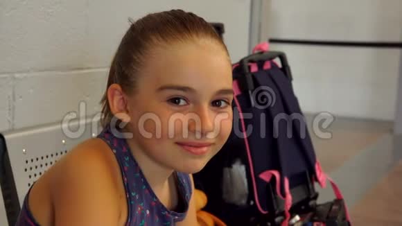 棕色大眼睛的可爱晒黑的女孩正坐在机场休息室里视频的预览图