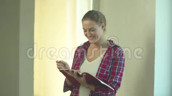 女人拿着笔记本站着写在里面视频的预览图