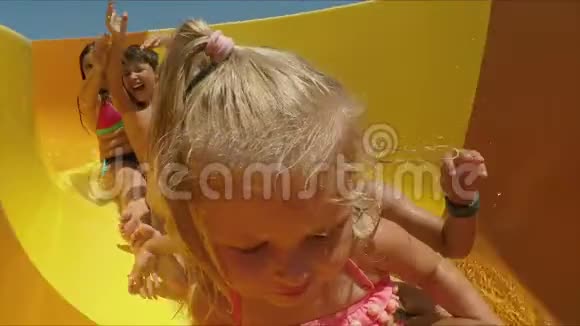 一群快乐的孩子在水上公园里骑着橘子滑梯视频的预览图