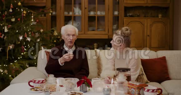 圣诞期间与祖父在家交谈的女人视频的预览图