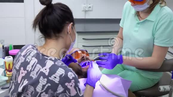 牙医正在护士的协助下进行专业的牙科清洁视频的预览图