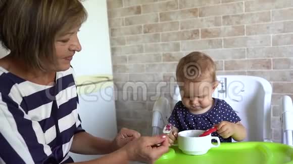 祖母在家给她的小孙女喂奶视频的预览图