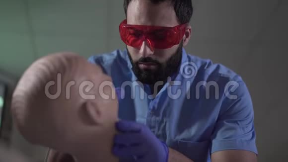 集中的中东男性口腔医生与牙科人体模型练习的特写自信英俊的医生视频的预览图