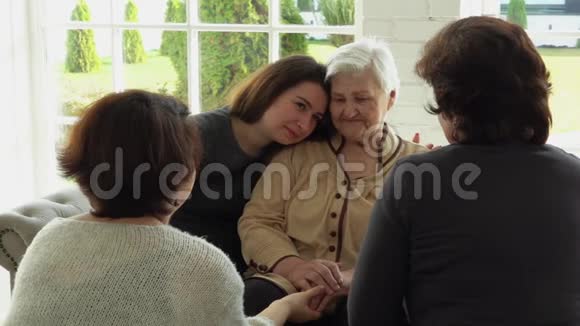 一位白发苍苍的老妇人和她的女儿和孙女坐在一起视频的预览图