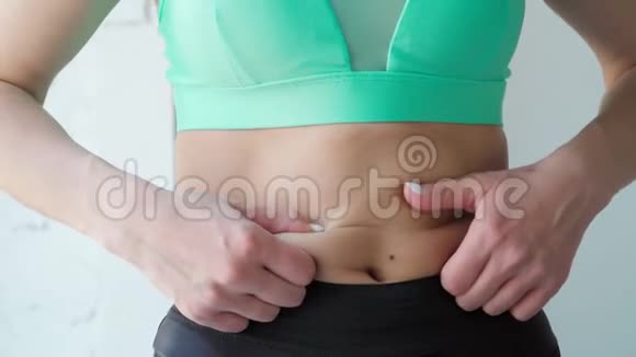 令人不安的运动女孩看着镜子触摸脂肪的肚皮关门视频的预览图