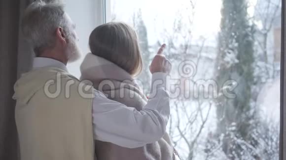 自信的中年白人男人指着窗户和年轻女人说话快乐的男性退休支出视频的预览图