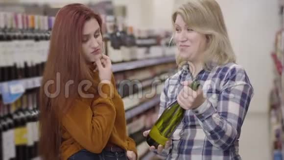 两个快乐的白种人女人在酒店里选择葡萄酒美丽的小姐们在酒中讨论饮料视频的预览图