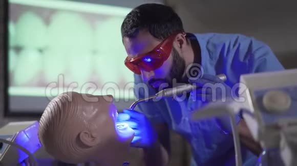 忙碌的中东口腔医生助理与牙科人体模型练习的肖像专注的年轻人视频的预览图