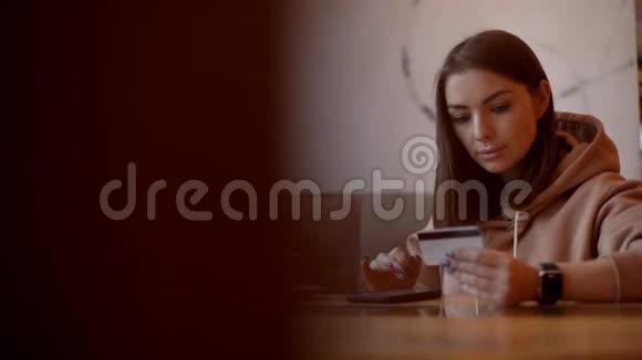 穿休闲服装的年轻女人用信用卡网上购物的肖像视频的预览图