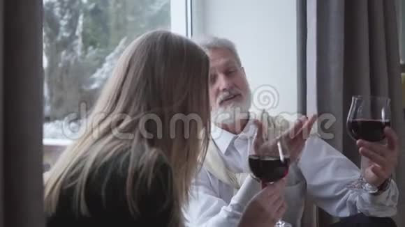 高级白种男性侍酒师与年轻女性谈论葡萄酒的味道和笑声快乐的退休老人视频的预览图