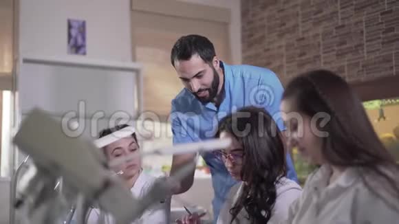 积极的中东专业口腔医师在口腔门诊教学学生年轻帅哥解释视频的预览图