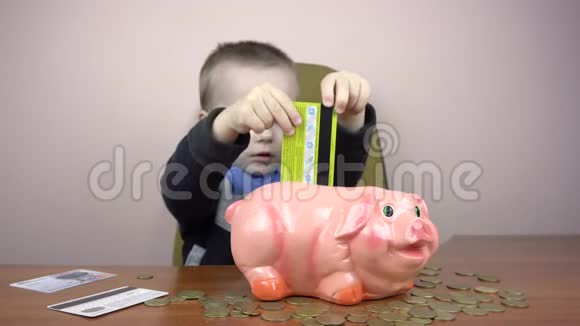小男孩试图在储蓄罐里戳一张信用卡视频的预览图